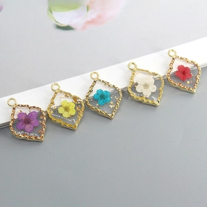 Golden scalloped alloy pendants with dried flowers and gold foil in clear resin
