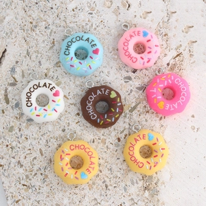 Detailed close-up of colorful resin doughnut pendants with chocolate text and heart accents