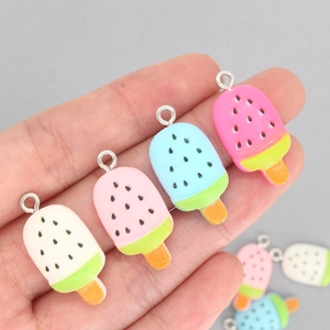 Handheld candy-colored resin popsicle pendants in white, pink, and blue with watermelon seeds