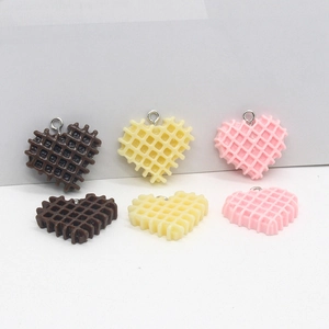 Makro-Detail von herzförmigen Waffel-Anhängern aus Harz in Braun, Gelb und Rosa