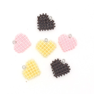 Detailansicht der herzförmigen Waffel-Anhänger in Braun, Rosa und Gelb aus Harzmaterial