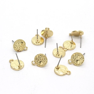Gros plan de composants d'oreilles ronds dorés martelés avec boucles pour bijoux DIY