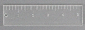Detail of acrylic ruler pendant with metric scale and hanging hole for DIY crafts