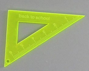 Macro detail of acrylic triangle ruler pendant with Back to School print for DIY jewelry