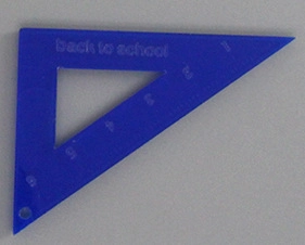 Detail showing a blue translucent acrylic triangle ruler with back to school text