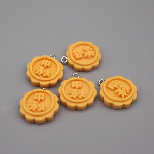 Macro detail of five orange resin mooncake pendants with Mid-Autumn festive engravings