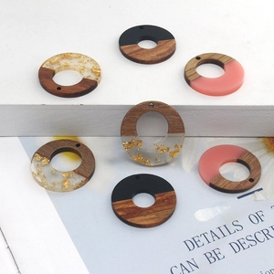 Detailed view of round resin wood charms with gold foil and matte finish for DIY jewelry