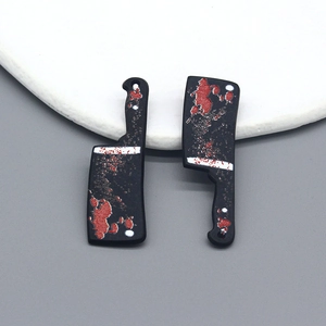 Detailed view of Halloween cleaver pendants with red splatter for DIY jewelry making