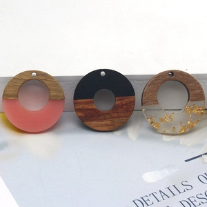 Detailed view of handmade wood and resin charms with gold foil flakes for DIY jewelry