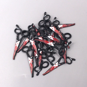 Gros plan de breloques ciseaux en acrylique avec éclaboussures de sang rouge pour bricolage Halloween