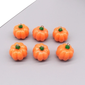 Vista macro di sei ciondoli a forma di zucca di Halloween arancioni con steli verdi