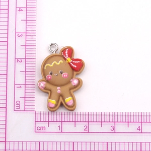 Close-up of gingerbread man pendant with red bow and size scale measurement
