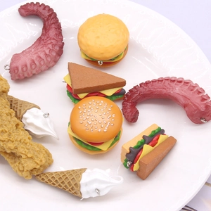 Variety of realistic PVC food pendants like burgers and ice cream in a white ceramic dish