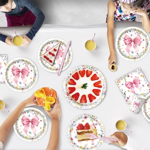 Overhead view of disposable party tableware featuring pink bows and wildflower floral patterns