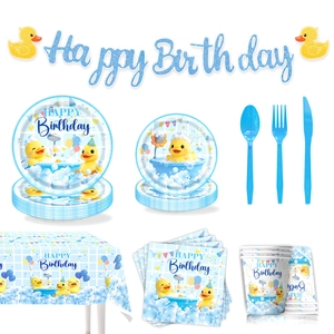 Flat lay of little duck theme birthday party tableware set with plates, cups and banner