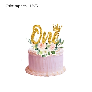Close-up of golden glitter 'One' cake topper with pink flowers for first birthday