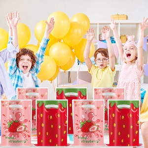 Detail of strawberry party favor bags featuring pink and red patterns with handle cutouts