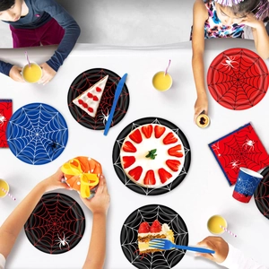 Flat lay of spider web theme disposable party plates cups and napkins on a white table
