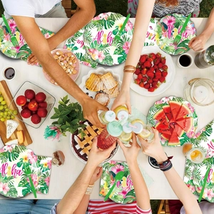 Flat lay of Hawaiian party tableware with floral plates, Aloha napkins and green forks