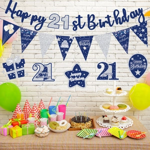 Detail view of 21st birthday party decorations with banners and hanging swirls on wall