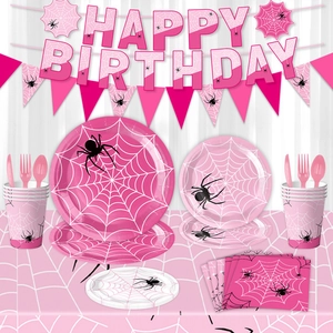 Close-up of pink spider web themed birthday party set with tableware and banners