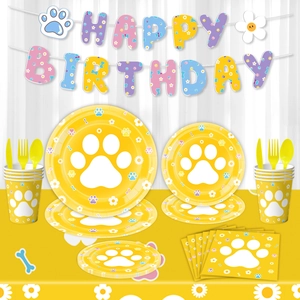 Bright yellow dog paw print party tableware set with Happy Birthday banner and plates
