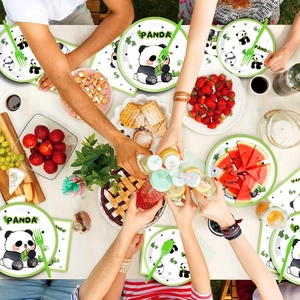 Panda themed birthday party tableware set with paper plates and napkins on wooden table