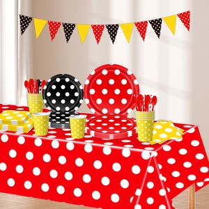 Close-up of polka dot party tableware set including plates, cups, napkins and banner