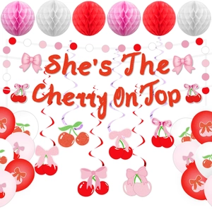 Detailed view of cherry party set with glitter banner and honeycomb paper balls