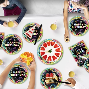 Overhead view of neon glow party tableware set including plates cups and napkins