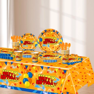 Macro detail of vibrant orange birthday tableware set with plates, cups and napkins