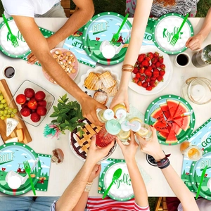 Close-up of golf themed party tableware set with plates, napkins, and cutlery on a table