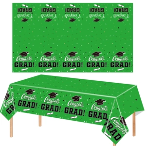 Close-up of green graduation tablecloth with Congrats GRAD lettering and mortarboard icons
