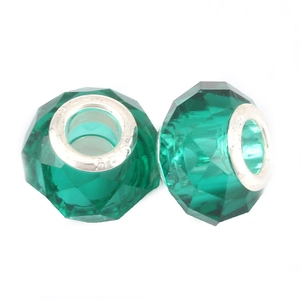 Macro view of two S925 sterling silver charms with faceted emerald green crystal beads