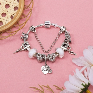Silver beaded snake chain bracelet with heart, crown, and pink glass charms on pink base