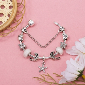 Silver charm bracelet featuring star, moon, and starfish pendants on a snake chain