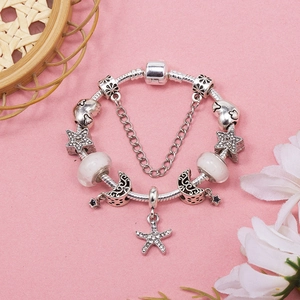 Silver snake chain bracelet featuring star and moon charms with a starfish pendant