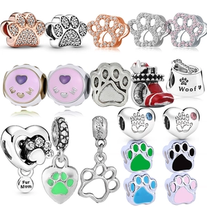 Macro detail of various animal paw and MOM themed charms with colorful enamel and crystals