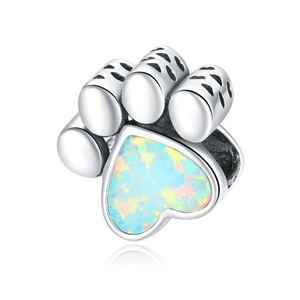 Macro shot of a cat paw jewelry bead with a heart opal stone and silver finish