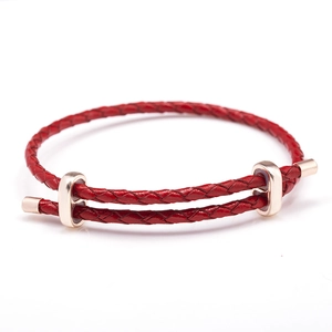 Bracelet en corde tressée rouge avec fermoirs en métal doré sur fond blanc pur