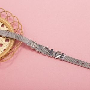 Detail of silver mesh bracelet featuring nautical and heart charms with adjustable buckle