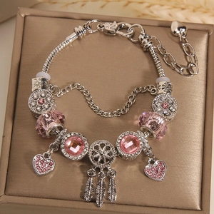 Detailed shot of a silver charm bracelet with pink crystal beads and dreamcatcher pendant