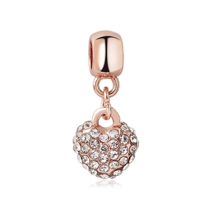 Macro shot of rose gold heart charm pendant featuring pavé-set shimmering crystals