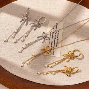 Elegantes Set aus Halskette und Ohrringen mit Schleife und Perlenquasten in Gold und Silber