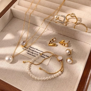 Elegantes goldenes Schmuckset mit Perlen und Quasten in einer edlen Holzbox