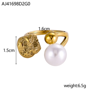 Detailansicht eines offenen Goldrings mit strukturierter Metallplatte, Goldkugel und Perle