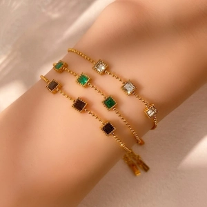Three-piece set of elegant gold beaded bracelets with colorful square emerald-cut gemstones