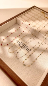 Detail of bohemian gold chains with multi-colored crystals in a wood jewelry box