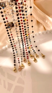 Macro detail of colorful faceted crystal beads with polished gold lobster clasps