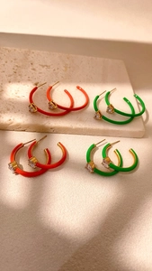 Detail of red and green enamel hoop earrings with heart shaped cubic zirconia stones